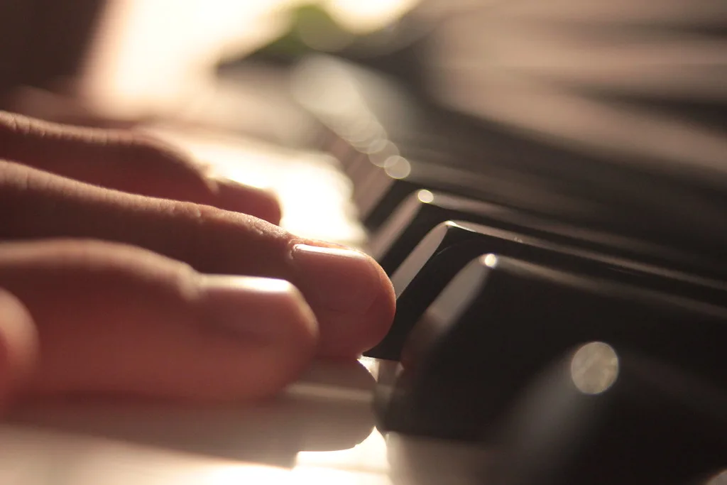 Une main joue sur un clavier, dans un flou lumineux